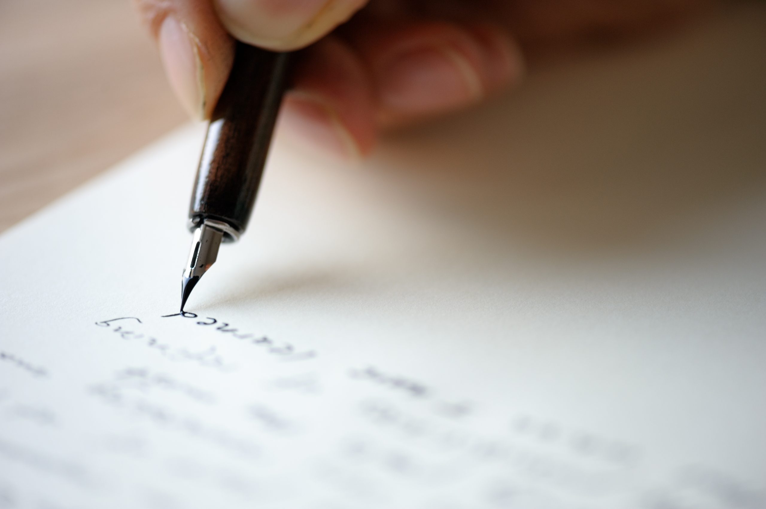 Hand die met een vulpen op papier schrijft